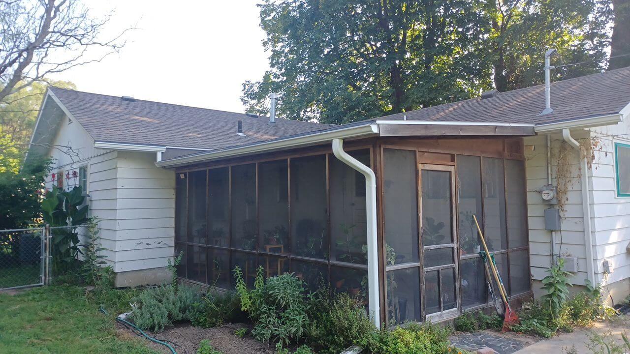 Lawrence KS house exterior with screened porch and overgrown garden