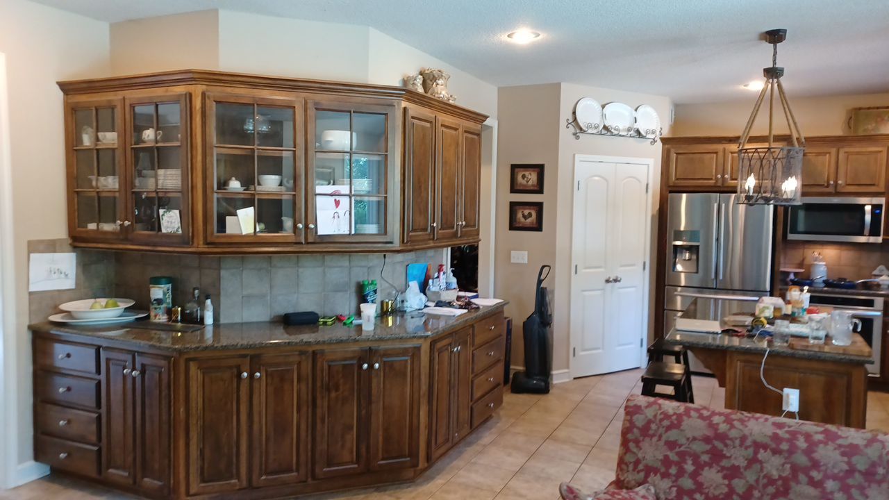Corner kitchen cabinets with glass doors, showcasing a refinished wood look