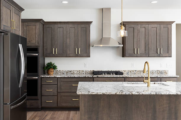 Dark grey cabinets with gold hardware and white marble tops by cabinet painting in Leawood, KS