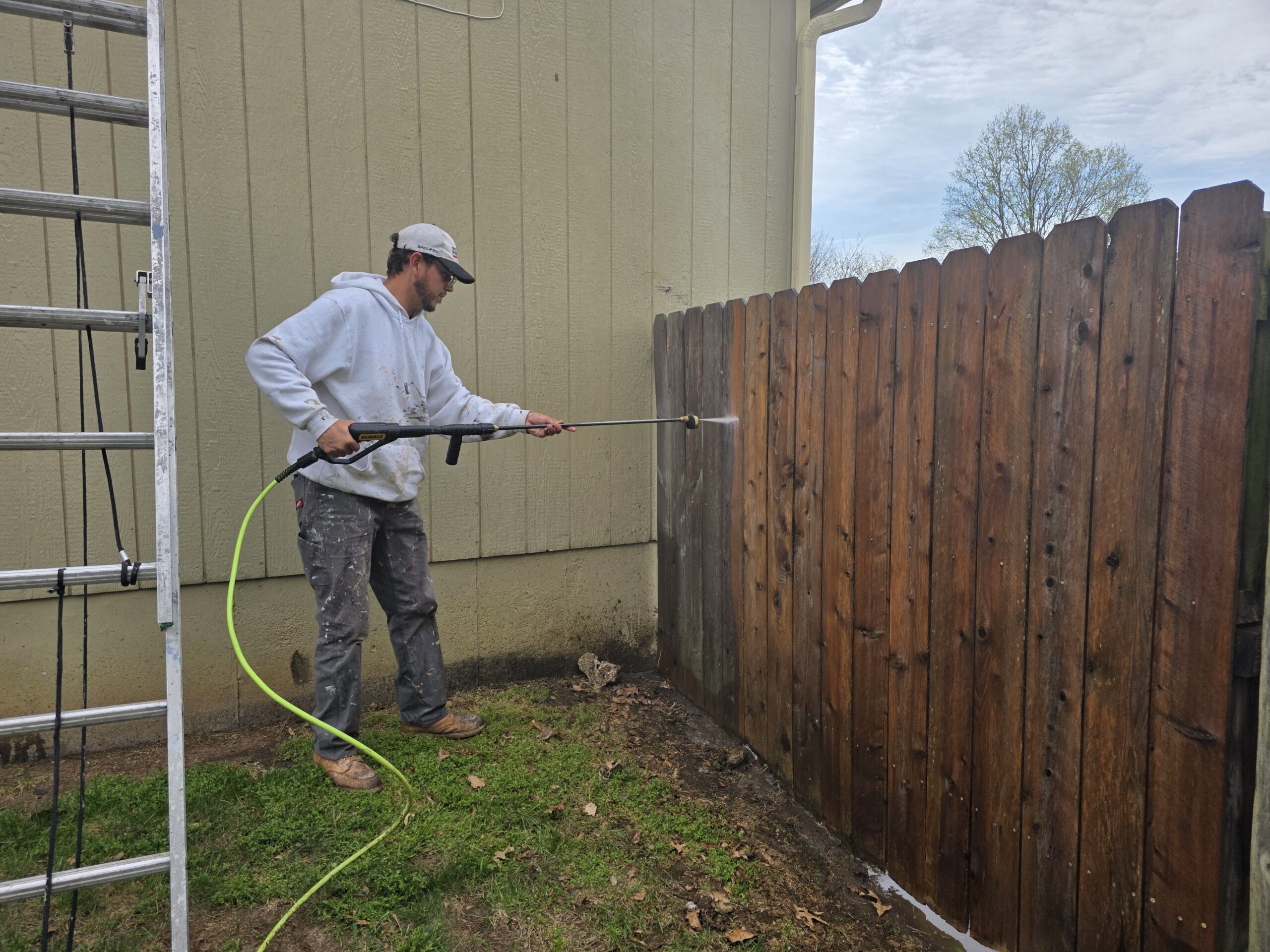 Man pressure washing a wooden fence in Topeka, KS.