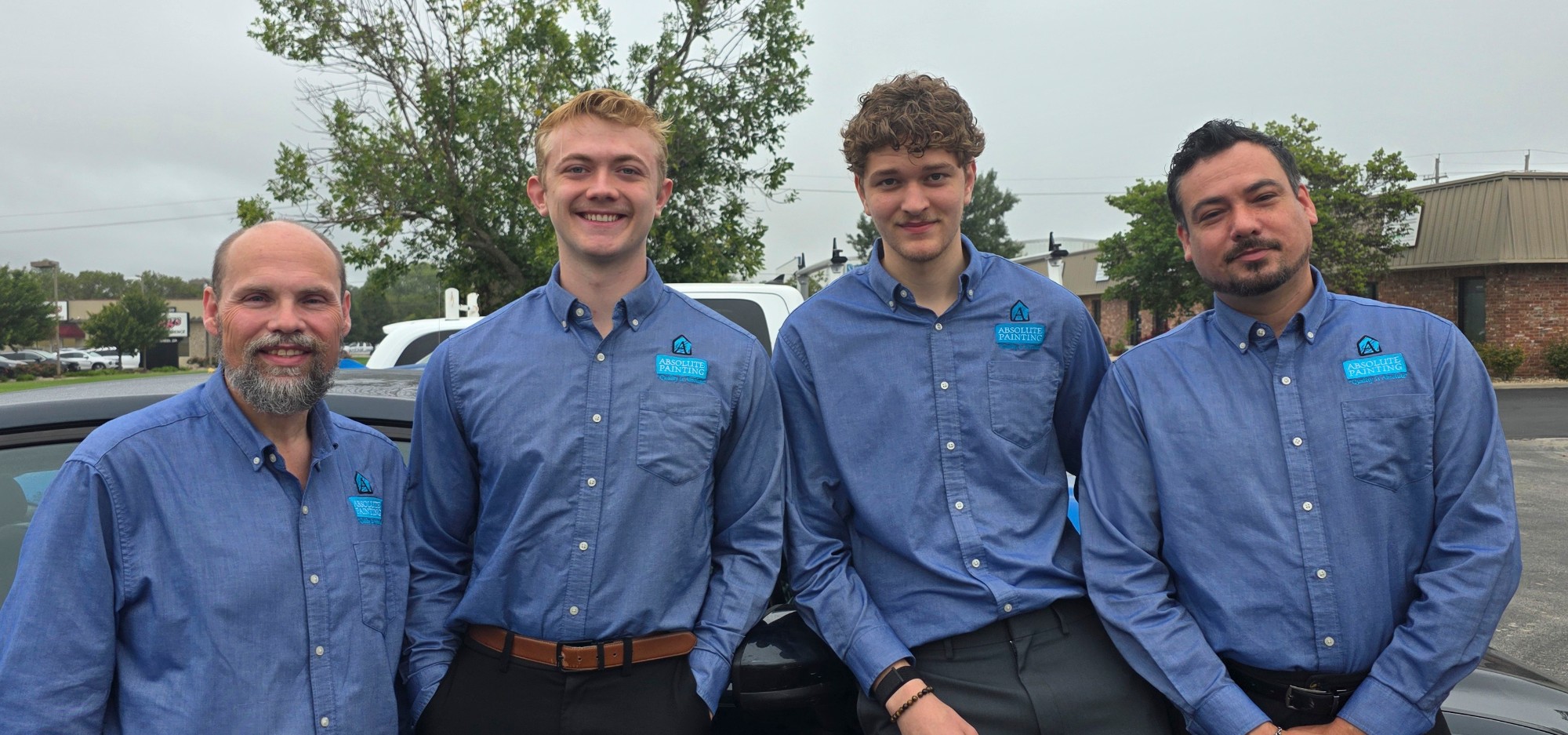 Absolute Painting sales team in company shirts standing together outside