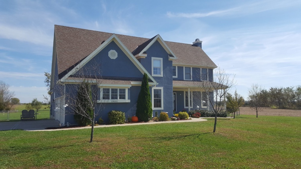 A dusty blue painted house with lawn in front- Exterior House Painting Services in Lawrence, KS